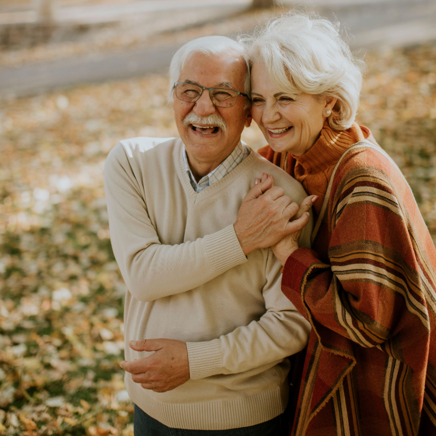 Older man and woman hugging and smiling.