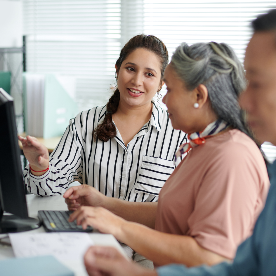Instructor helping adults learn computer skills.