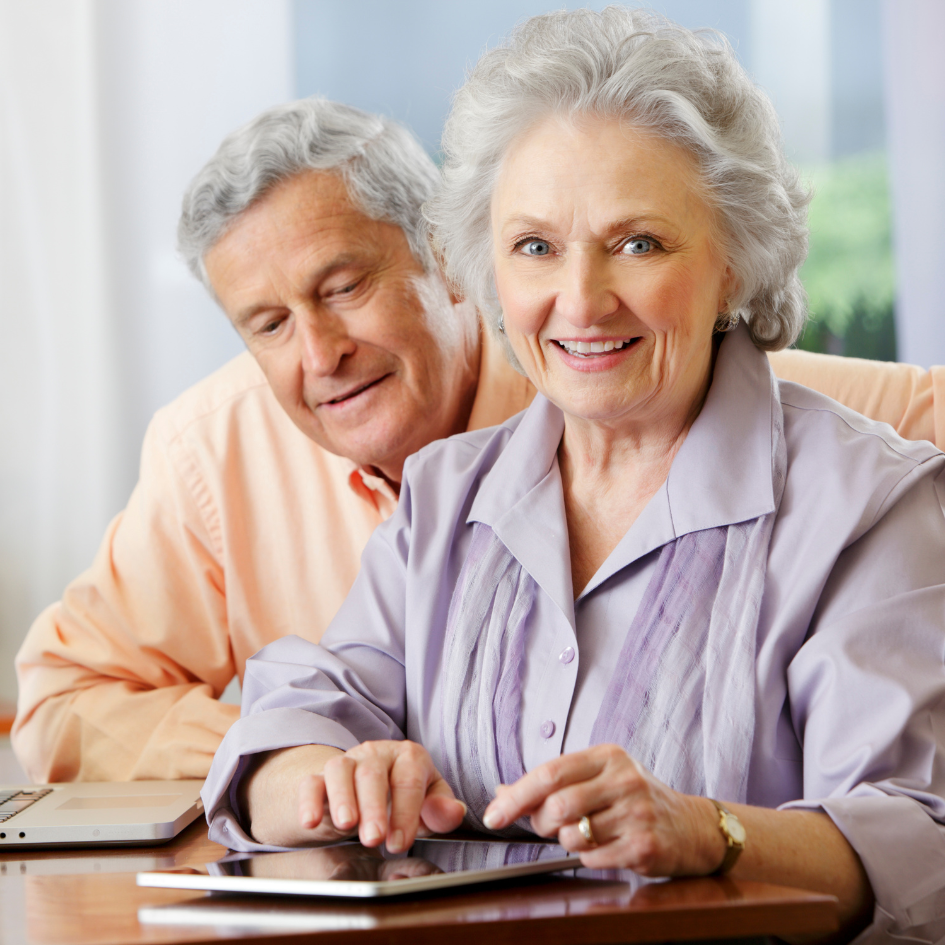 Older adults using a tablet together.