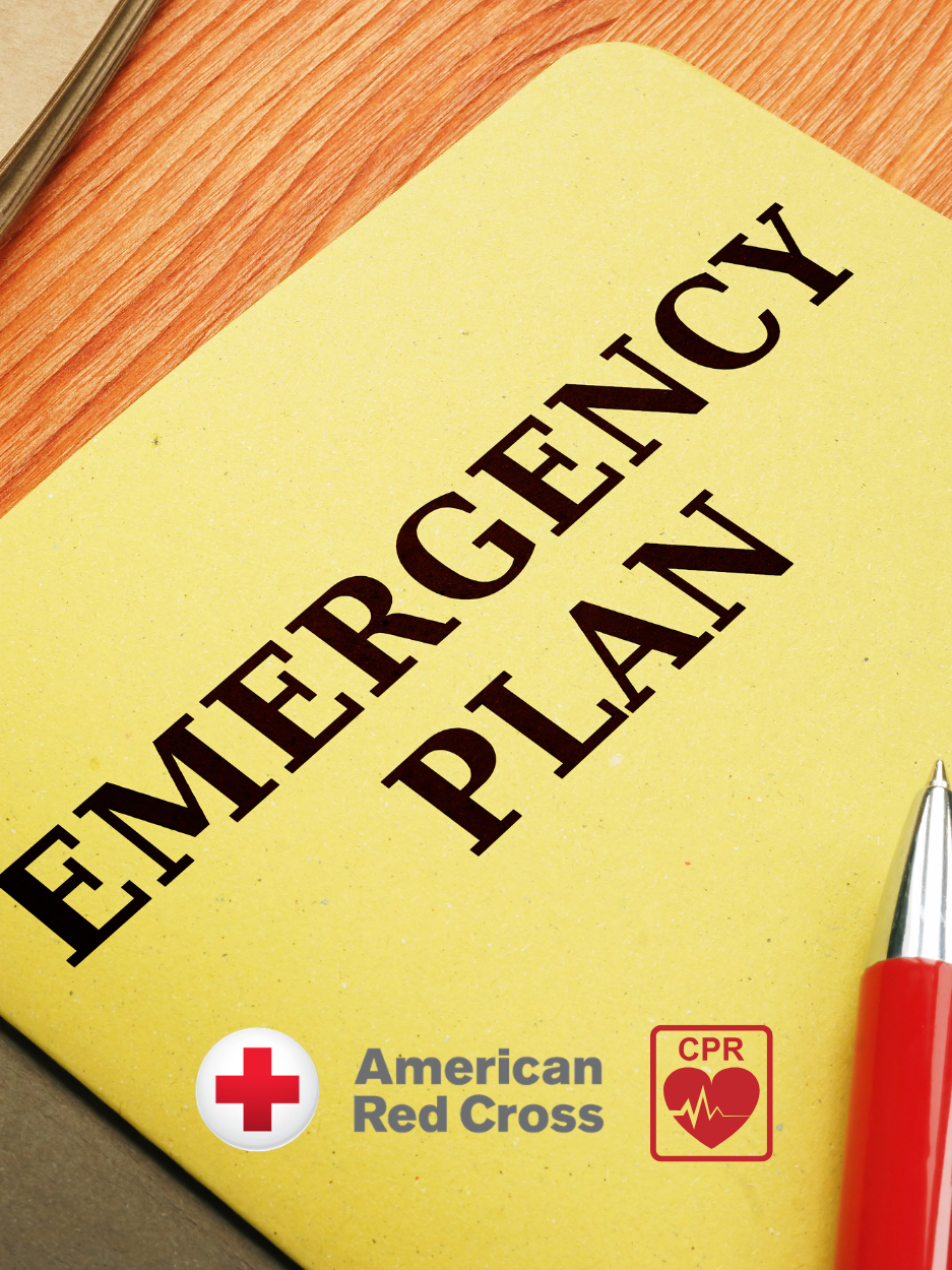 Close-up of a yellow folder labeled “EMERGENCY PLAN” in large black letters on a wooden surface. A red pen rests along the right edge. At the bottom are the American Red Cross logo and a CPR heart icon, indicating emergency preparedness and CPR training.