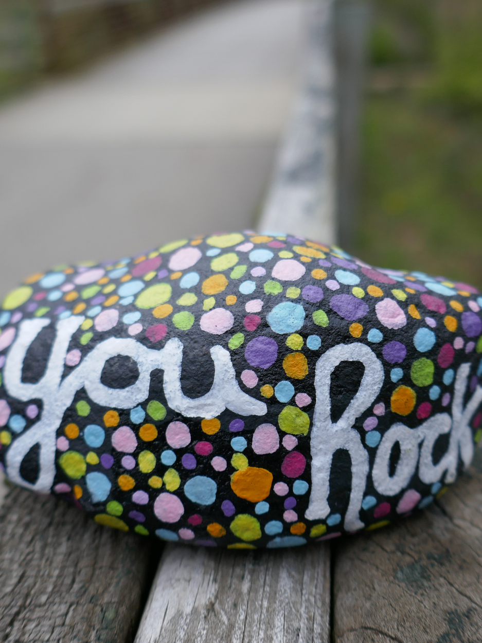 Painted rock with colorful dots.