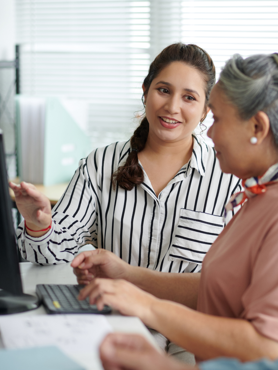A person instructing another person on a computer.