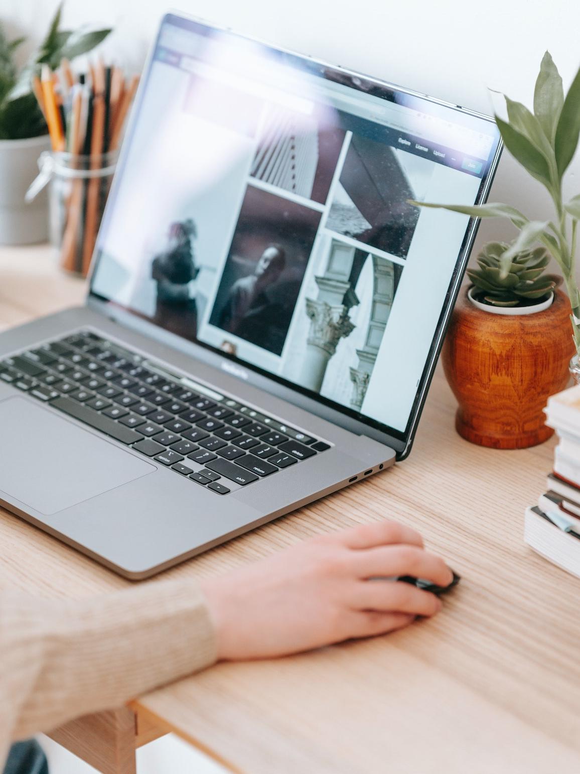 person using a mouse and a laptop