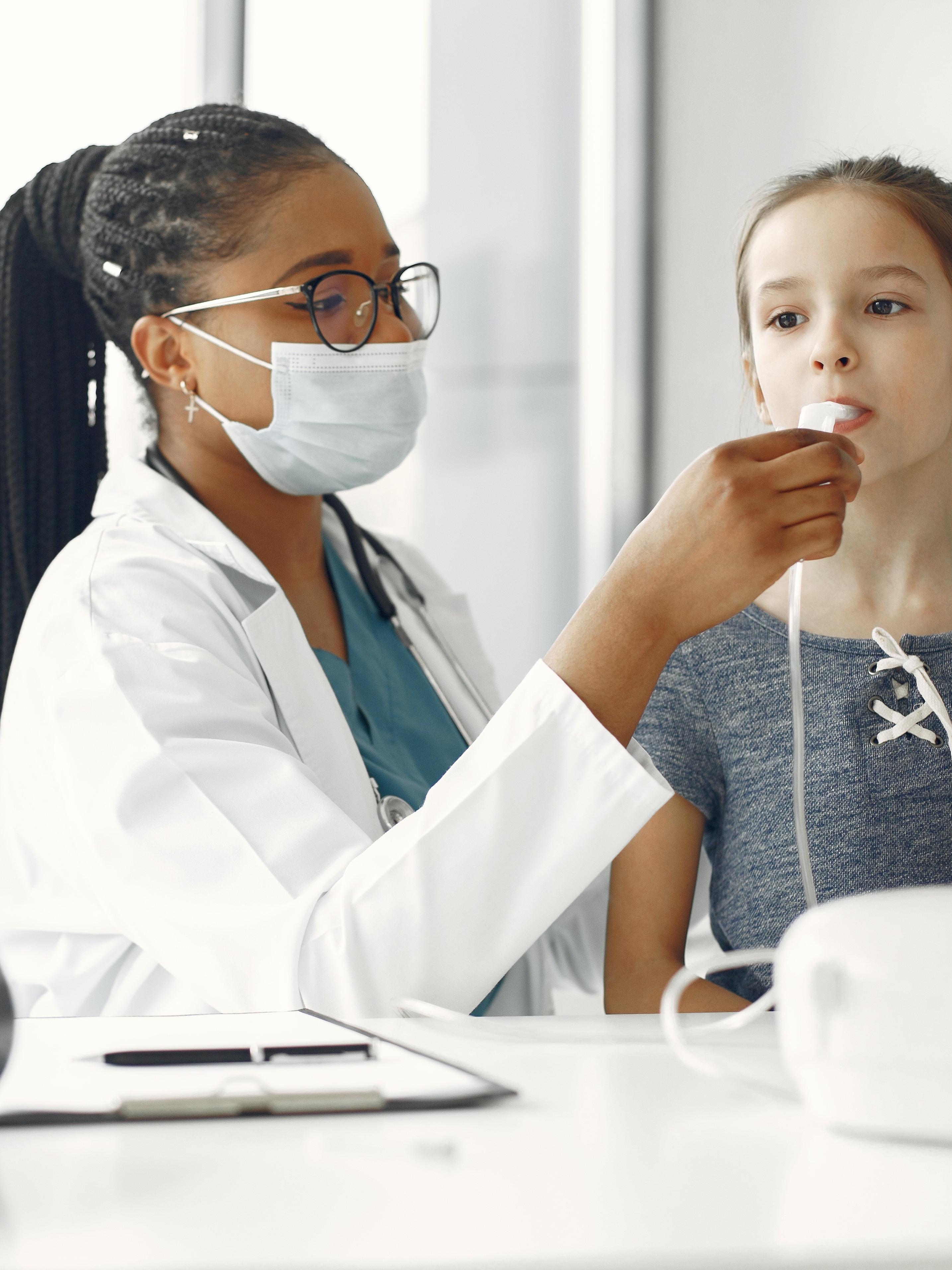 medical professional helping a child with a medical device