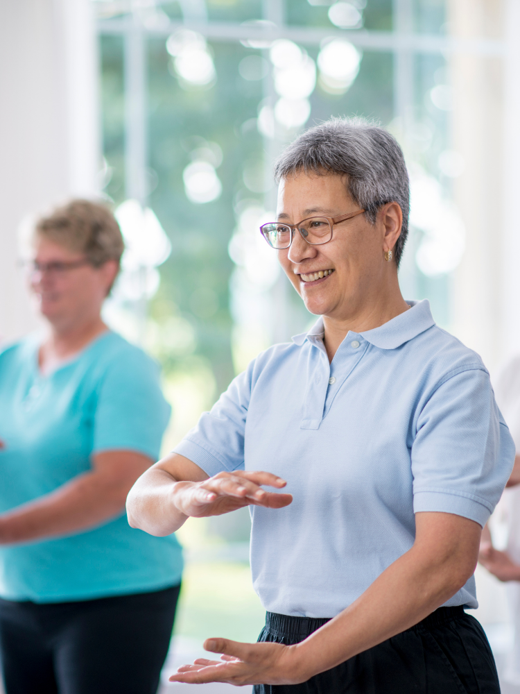 Two people practicing qigong exercise moves.