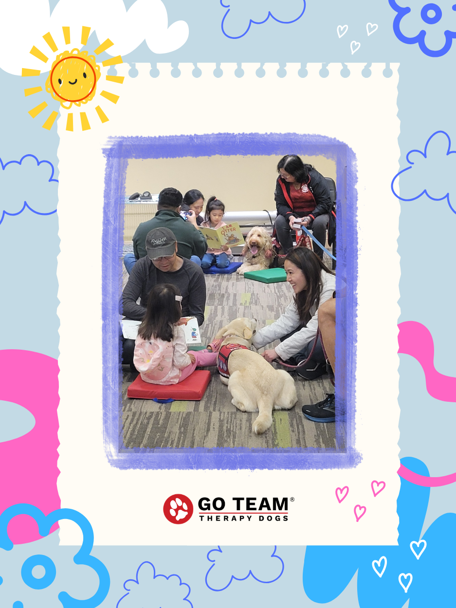 Children sit on floor cushions reading aloud to therapy dogs during a library program, while caregivers and volunteers look on. The photo is framed by a colorful border with clouds, hearts, and a smiling sun, and includes the GO TEAM Therapy Dogs logo at the bottom.