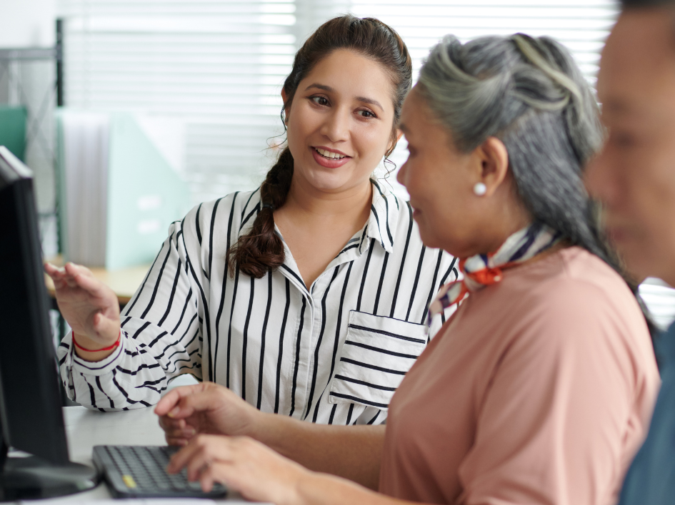 Instructor helping adults learn computer skills.
