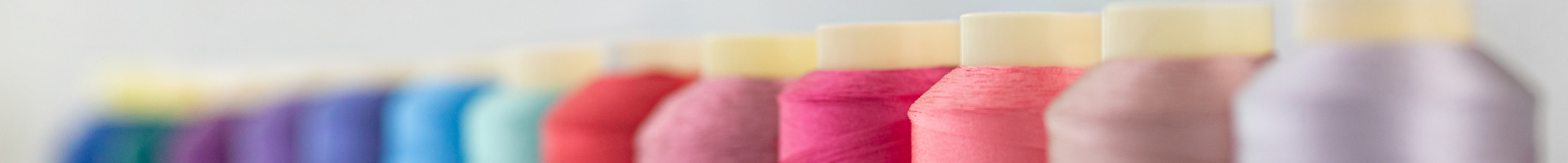 Colorful sewing thread spools in a row.